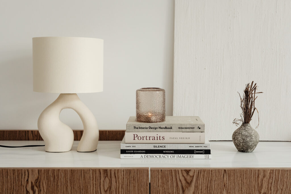 Vignette of books and lamp on table. Frequently asked questions for interior design services