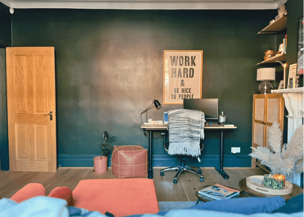 Image of a transformed living room into a multi-functional home office with dark green walls and a workspace home office showing the use of studio green by farrow and ball in north facing room